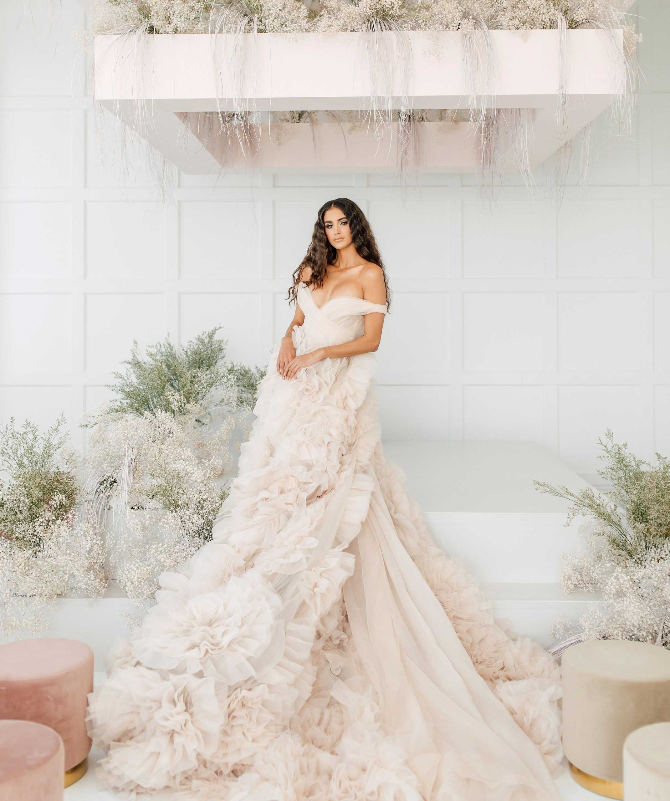 Bride in a ruffled gown in a white loft with pampas grass
