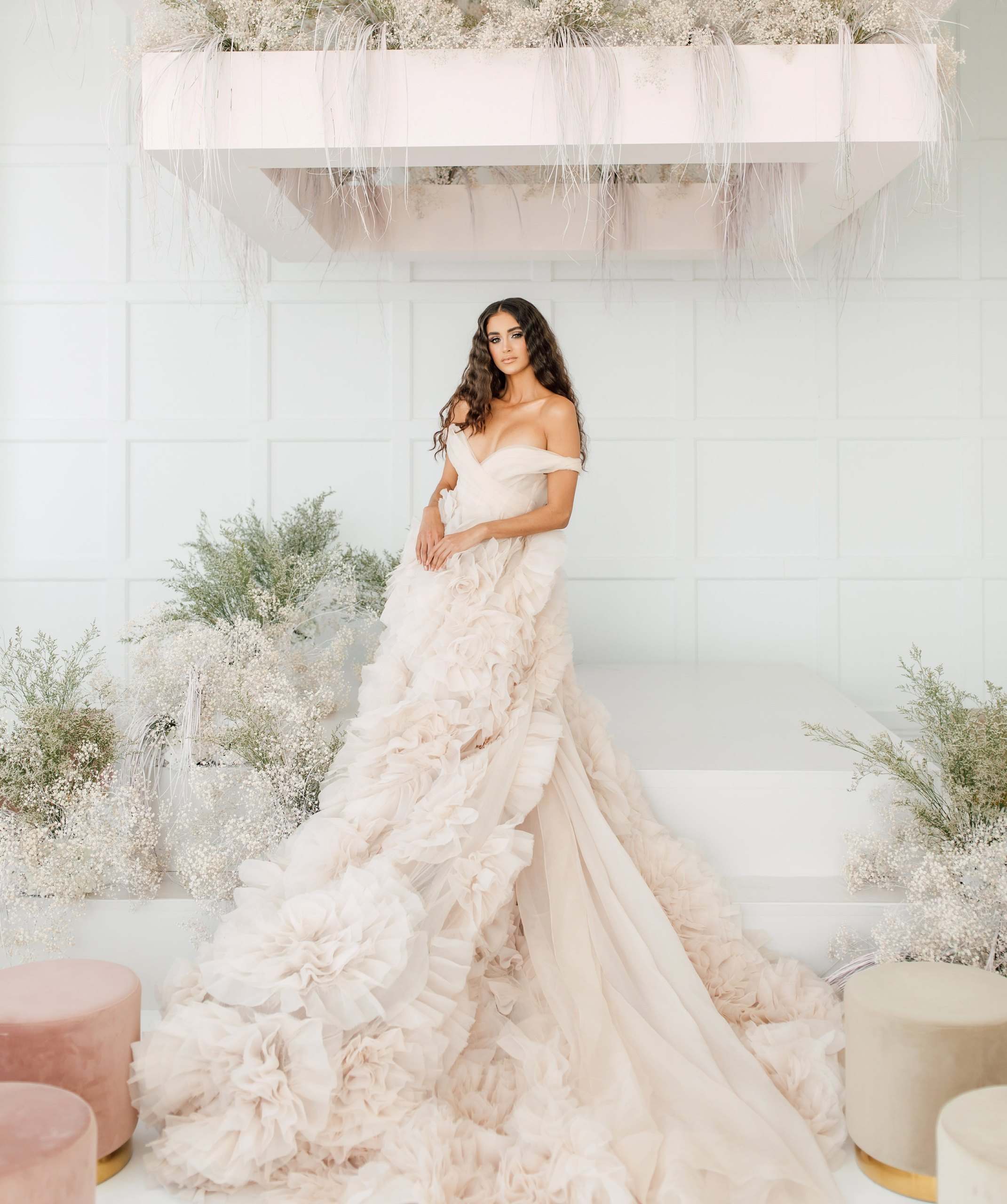 Bride in a ruffled gown in a white loft with pampas grass