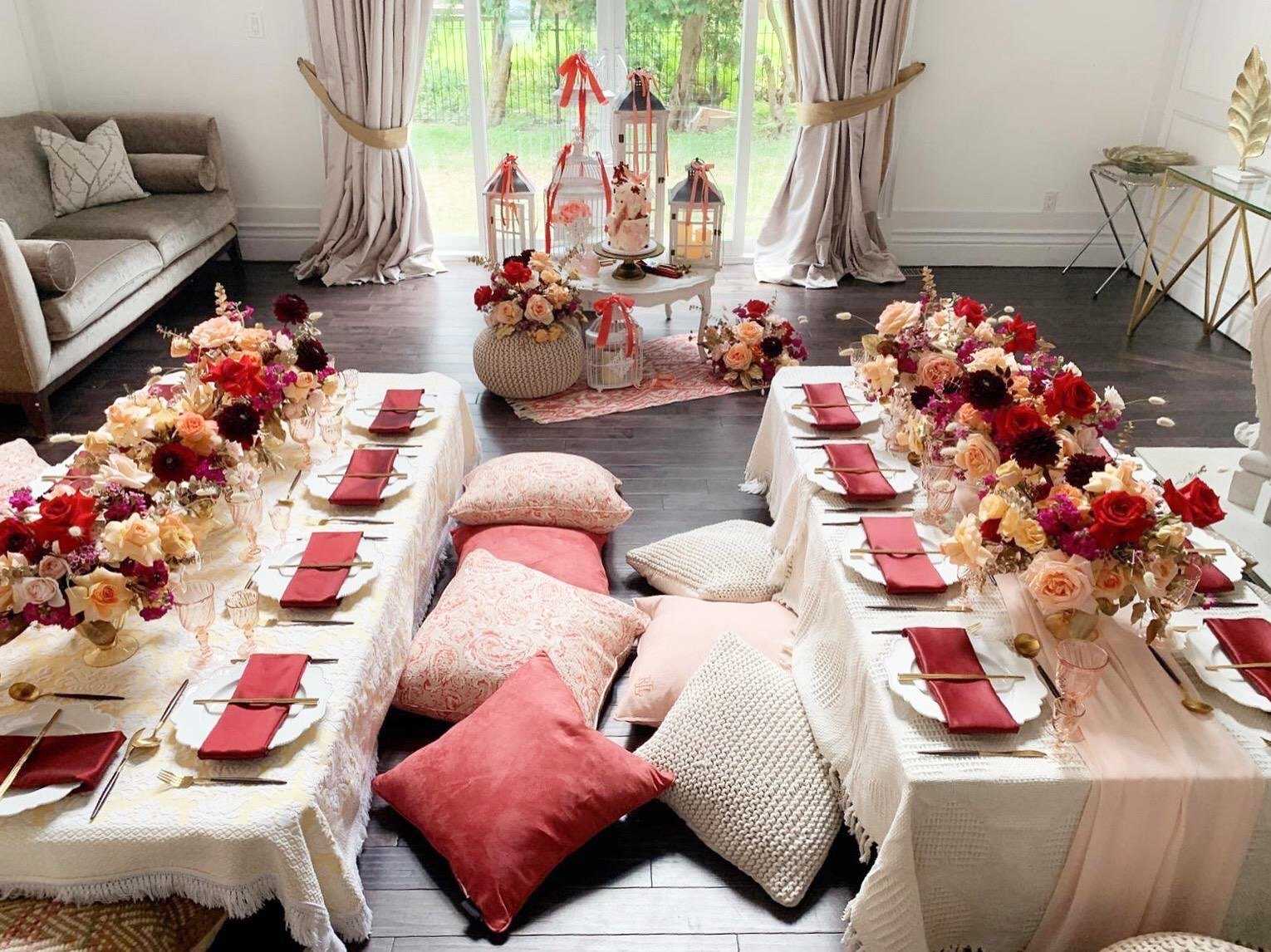 Low floor dining with cushions, crimson florals and lanterns