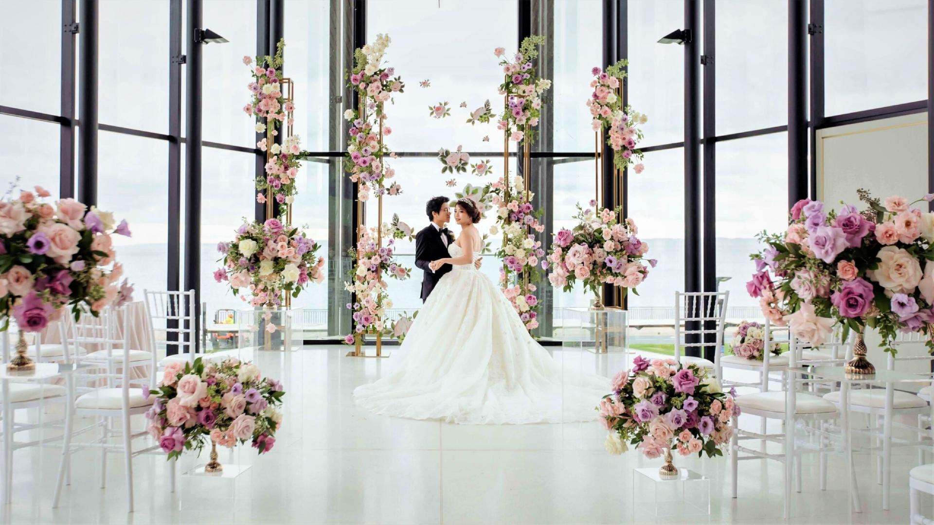 Couple in a glass pavilion between hanging pastel floral columns