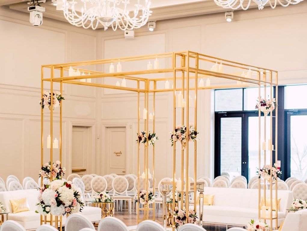 Gold geometric canopy frame over a white lounge set