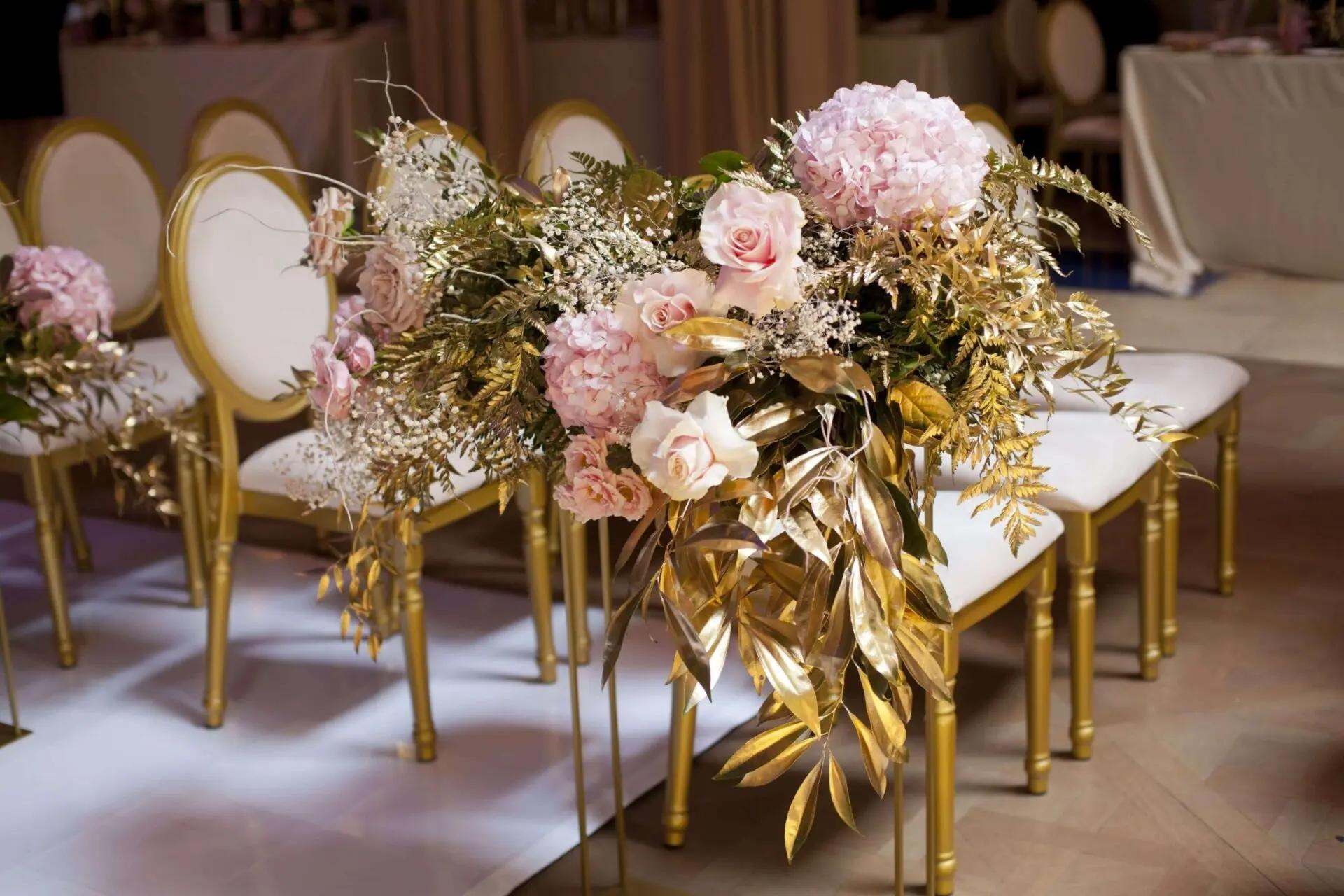 Gold oval chairs with blush hydrangea and gilded leaves