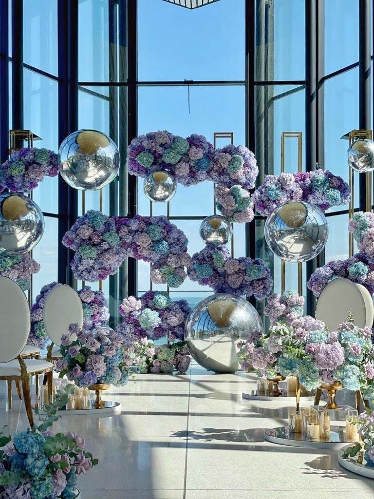 Blue and purple hydrangea clouds with mirror balls by a window