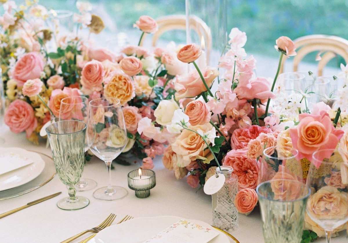 Peach and coral rose centerpiece with green glassware