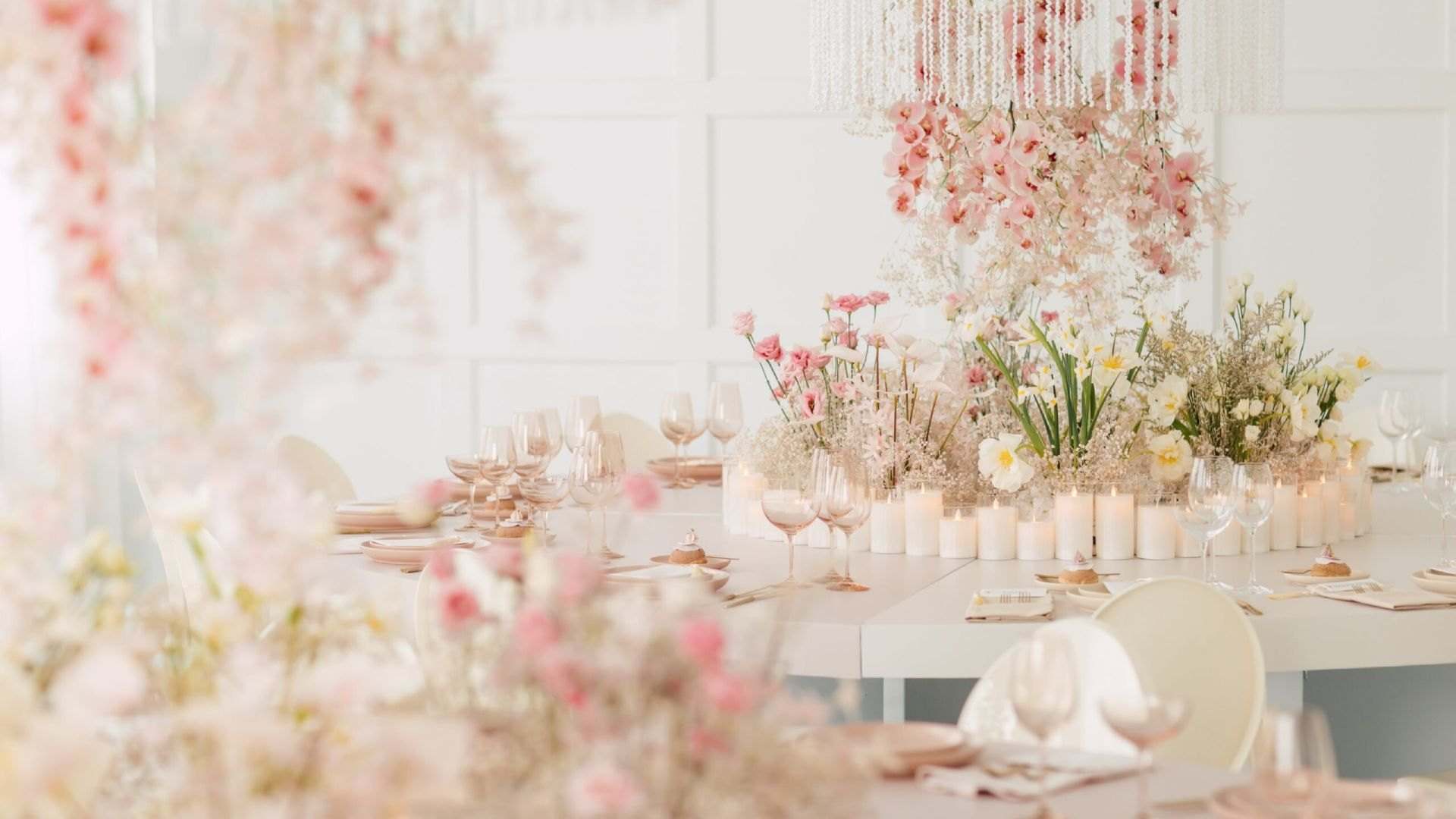 Long table with hanging pink blossoms and candles