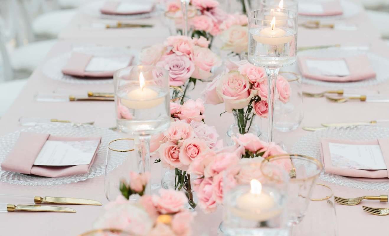 Pink carnation runner with floating candles and gold flatware