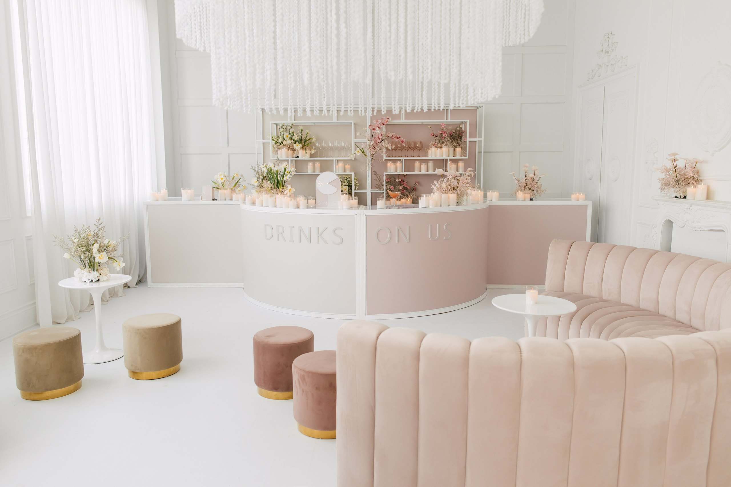 Blush velvet lounge and a white bar under a crystal ceiling