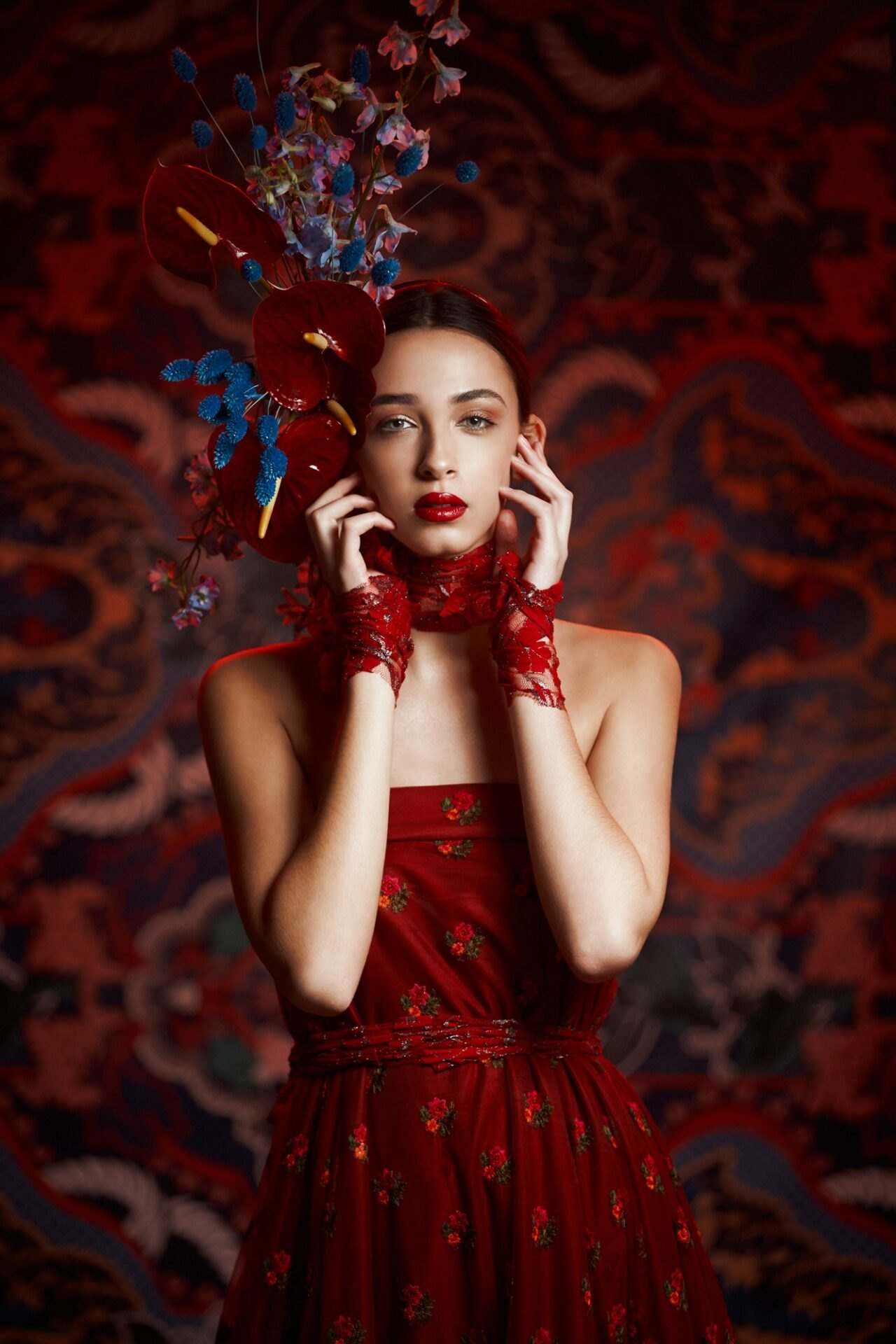 Model in red lace with a blue floral headpiece