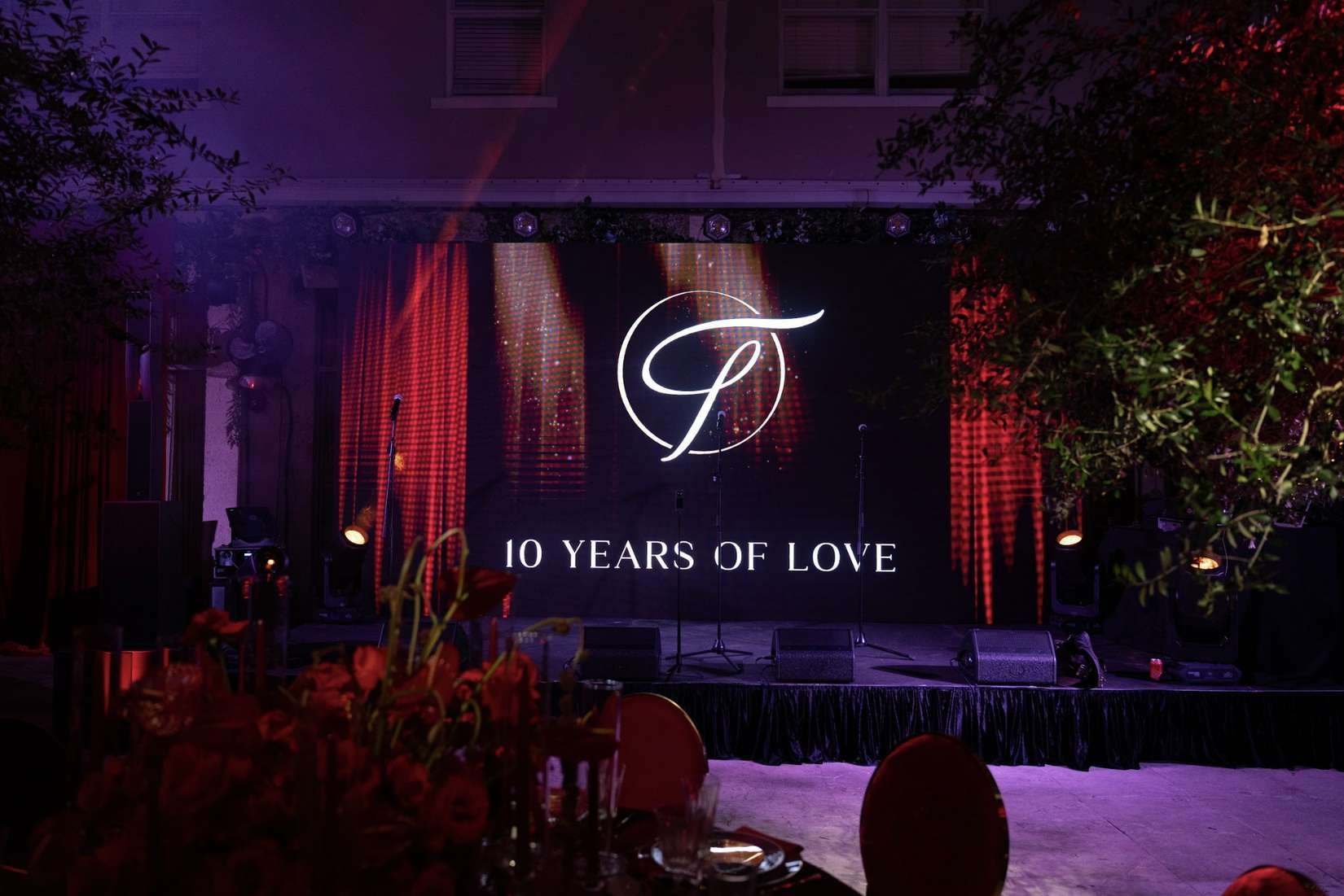 Anniversary stage with a monogram screen reading 10 Years of Love and red lighting