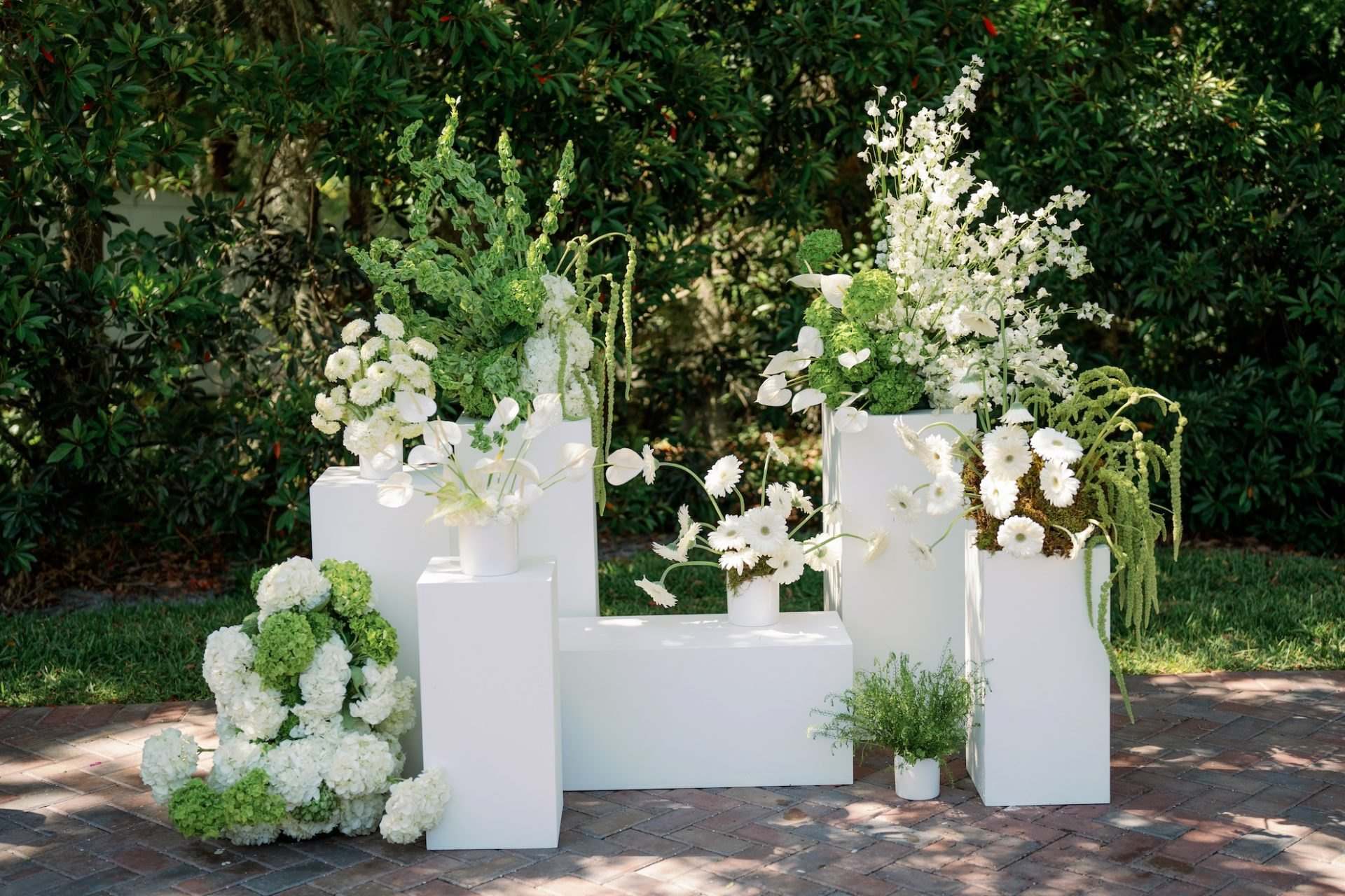 White plinths with hydrangeas and delphinium on a garden terrace