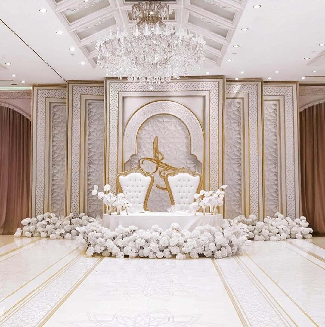 Ivory stage with carved panels, two throne chairs and white florals