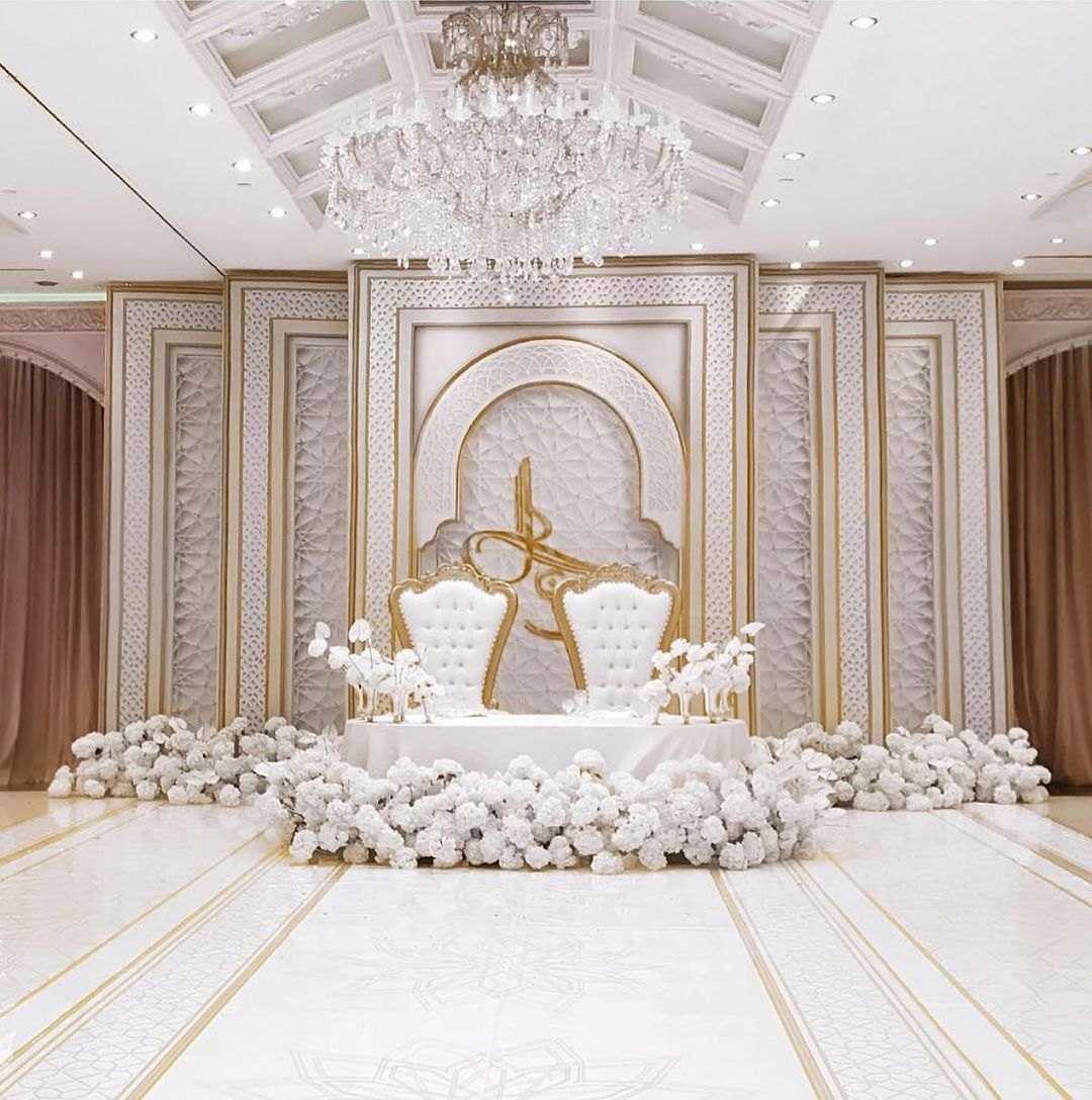 Ivory stage with carved panels, two throne chairs and white florals